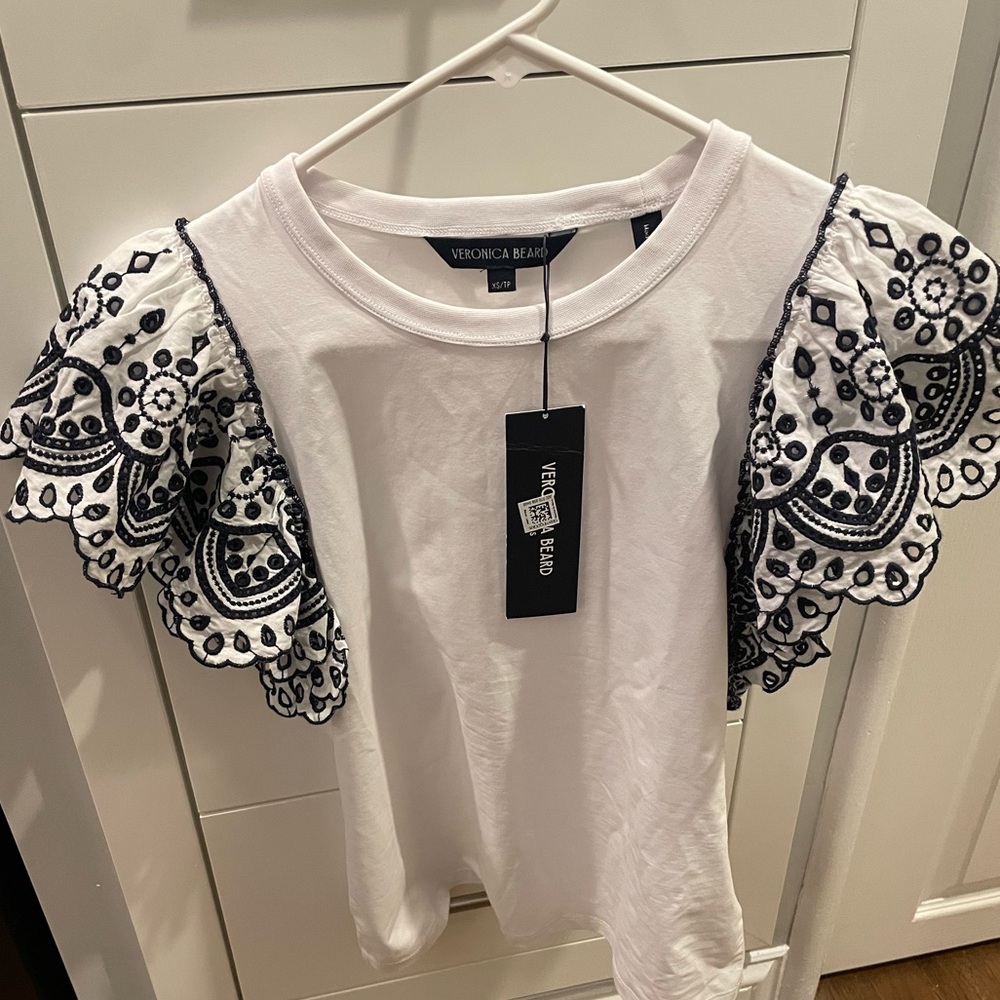 Like new Veronica Beard stretchy white tee with navy eyelet trim.